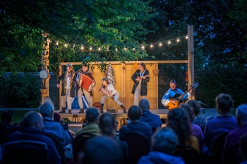 People acting on stage in the open air