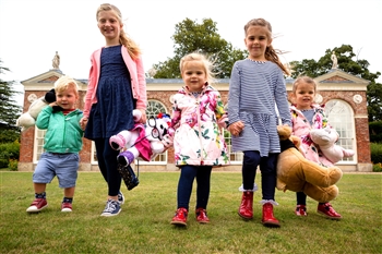 Children walking in the park with their teddy bears