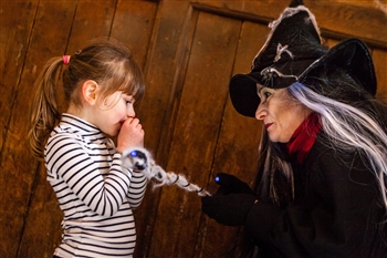 Lady dressed as a witch with a young girl